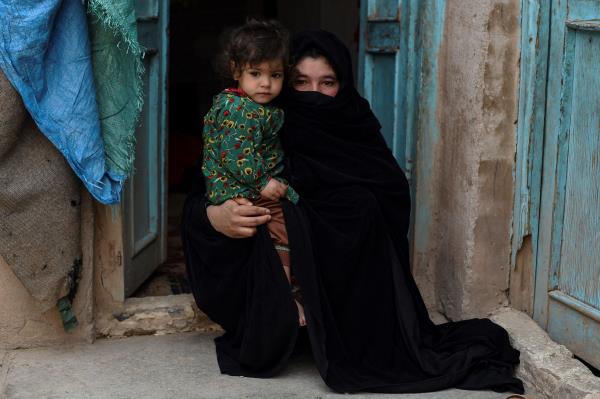  In this photo taken on Feb. 3, 2022, Aziza, who plans to sell her kidney to raise mo<em></em>ney for her family, poses with her young daughter Parwina at their house in Herat.